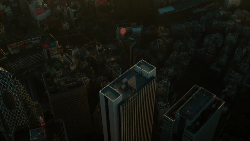 A tall narrow skyscraper looms over shorter buildings downtown