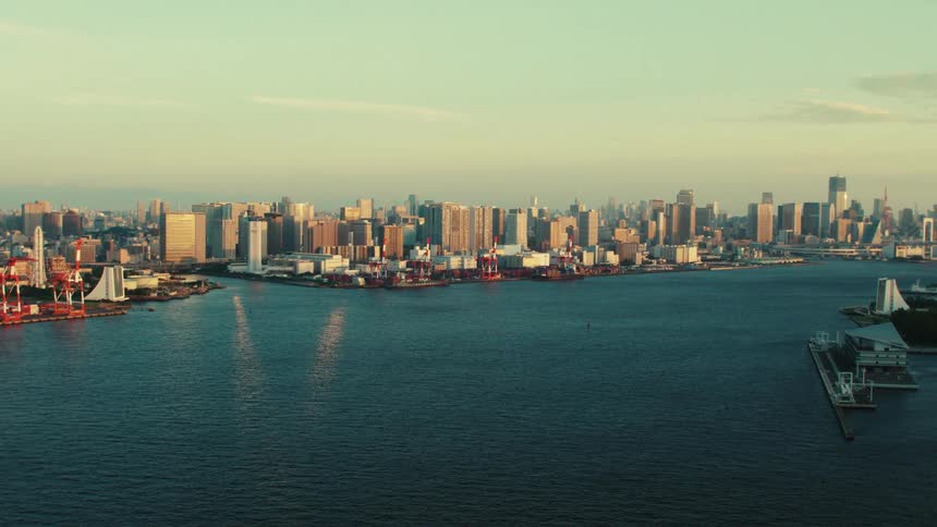 An aerial view of buildings and skyscrapers next to a large body of water