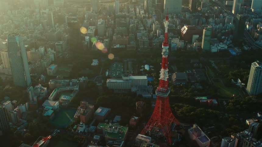 Construction cranes sit on roof of building near red tokyo tower