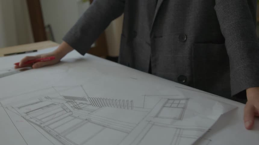 A view of a person working in an office drawing a design