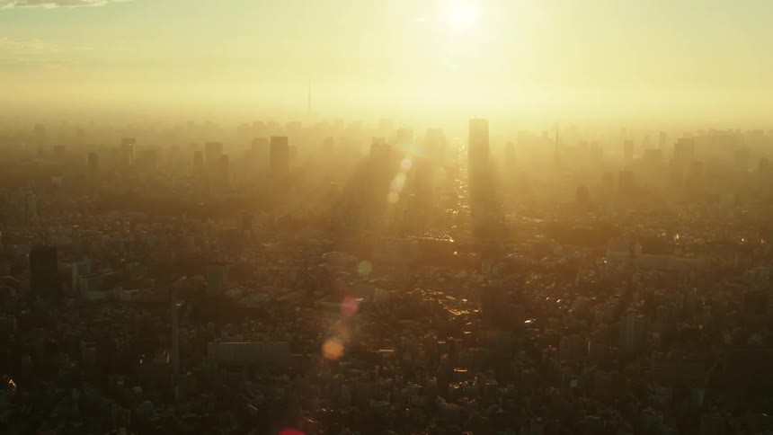 An aerial view of bright sunlight shining over a hazy city