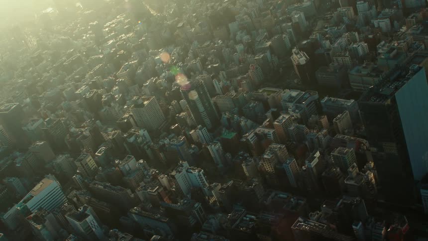 Aerial view of sun shining on buildings and office buildings in the city