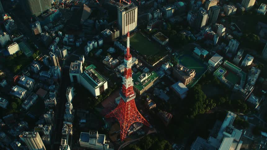 A tall red and white tower in a city