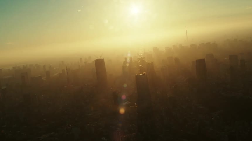 The city is covered in haze and clouds at sunrise