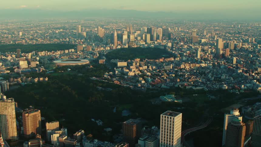 An aerial view of buildings and skyscrapers in a large city at sunrise