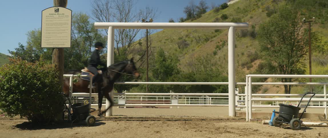 A woman is horseback riding