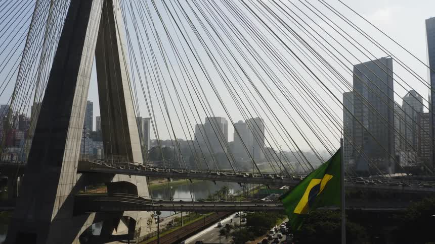 An aerial view of vehicles traveling over an urban suspension bridge