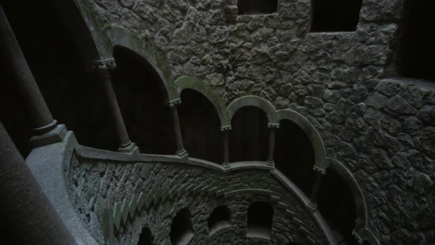 A stone staircase spirals downward