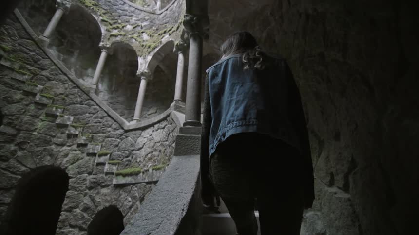 A woman walks up some stone stairs