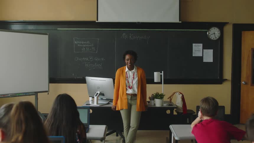 A teacher stands in front of a classroom of students