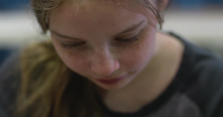 A young girl smiles and looks up