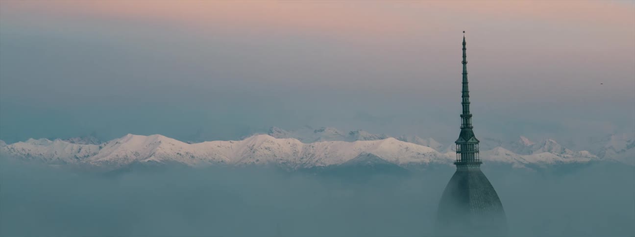 A view of a spire in front of mountains
