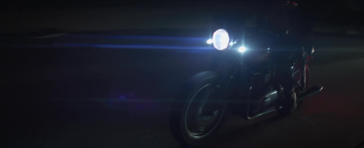 Biker rides motorcycle on highway at night