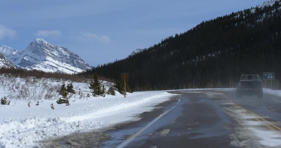 A truck drives on a snowy mountain road