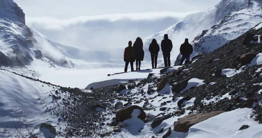 A group of people are standing before a mountain range