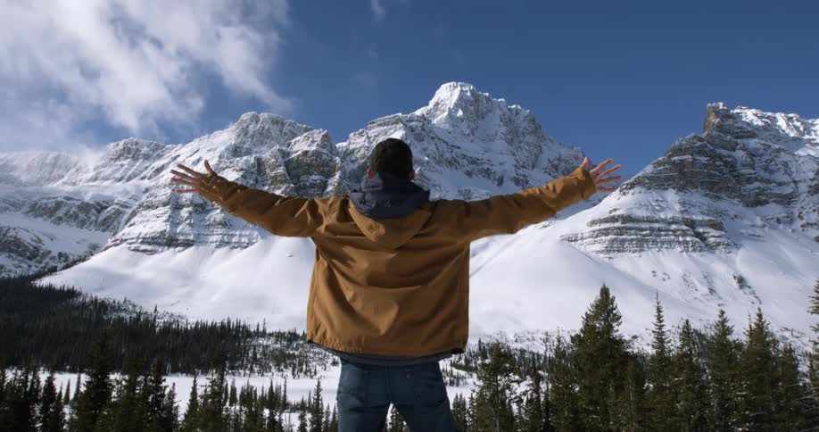 A man is standing on a field with his arms stretched out
