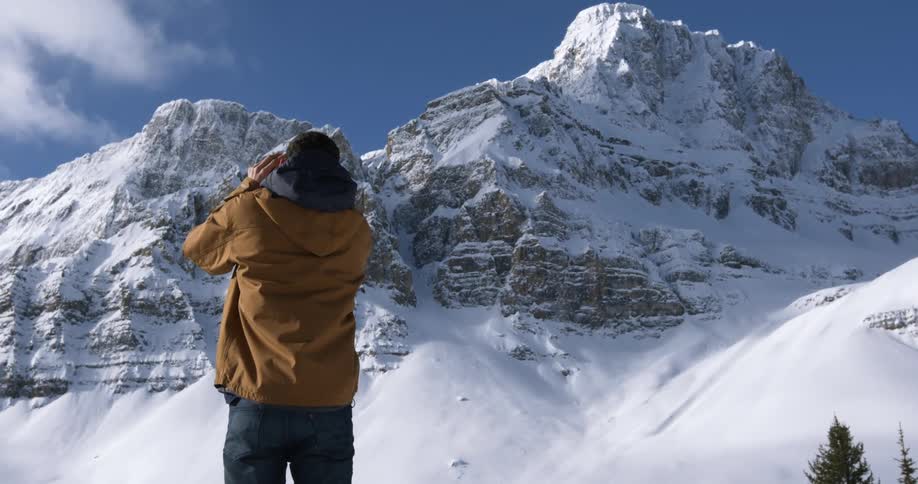 A man photographing snow-covered mountain tops