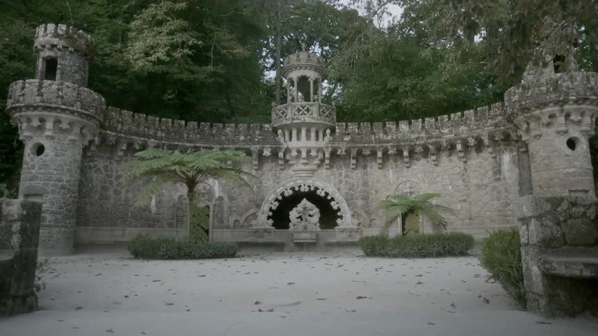 A curved stone structure in the forest