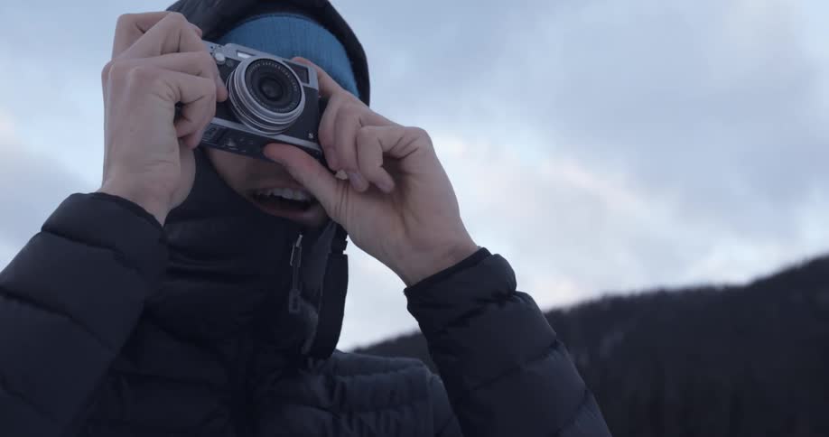 A man taking photographs outdoors during the winter