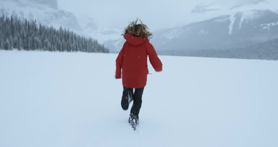 A woman is running on a field with heavy snow