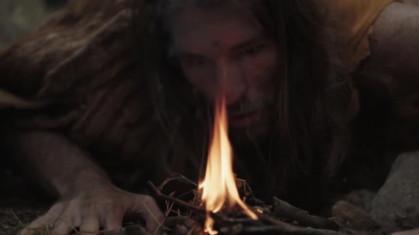 A man blows on a fire