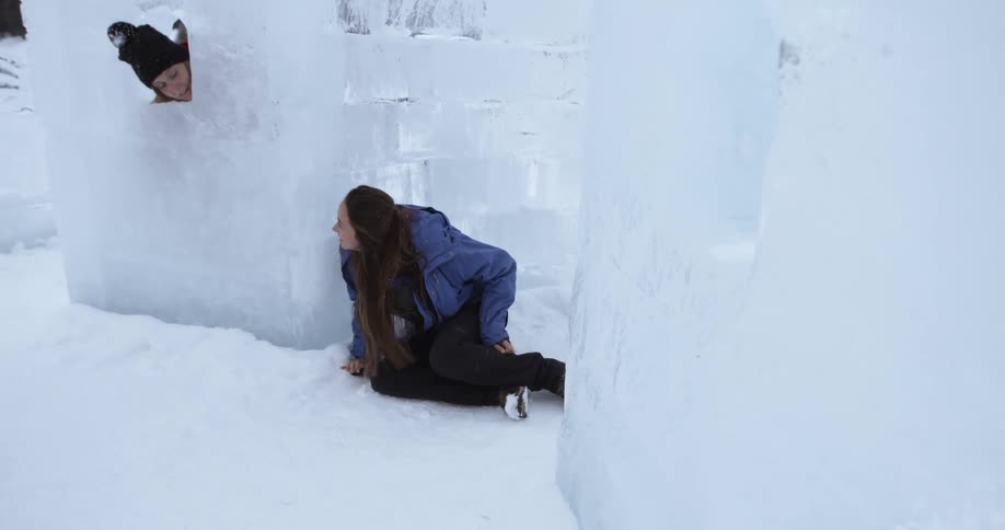 A pair of women talk near walls of ice