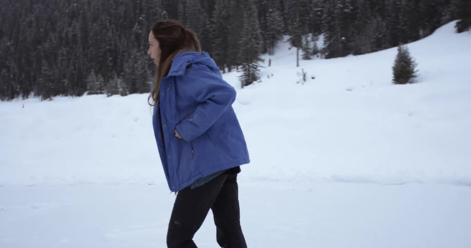 A woman in a coat ice skates and dances around