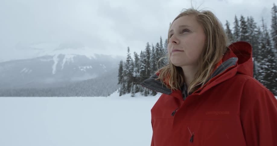 A woman standing outside as snow falls