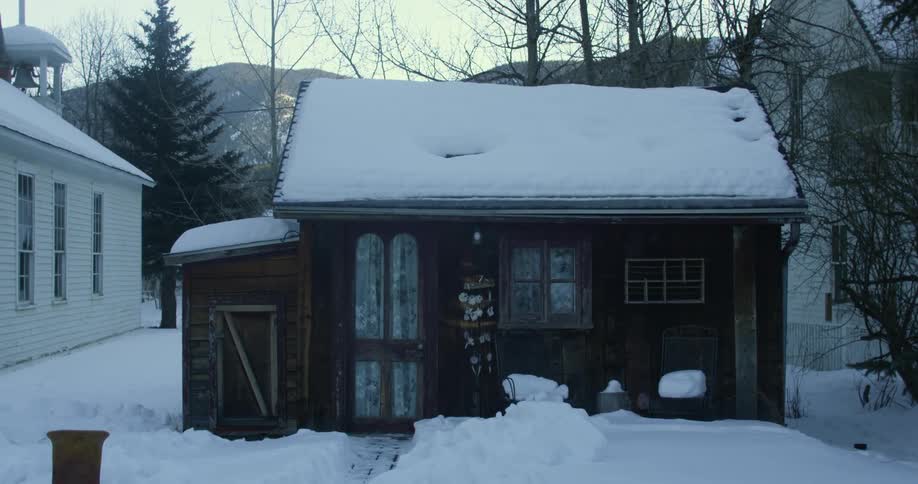 A home is covered and surrounded by snow