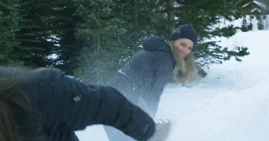 Two women are having a snowball fight