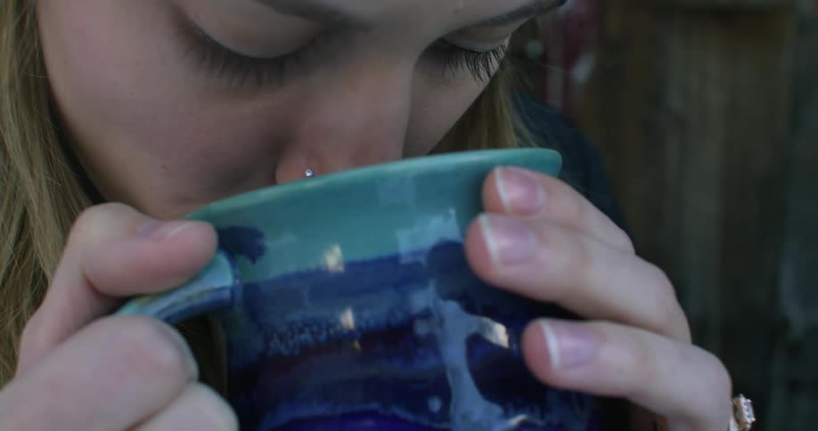 A woman drinks from a mug