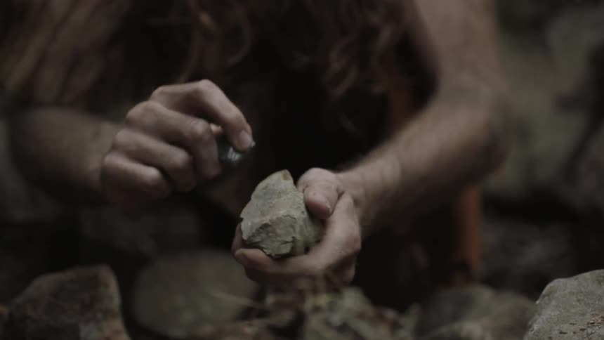 Man strikes two rocks together and ignites sparks