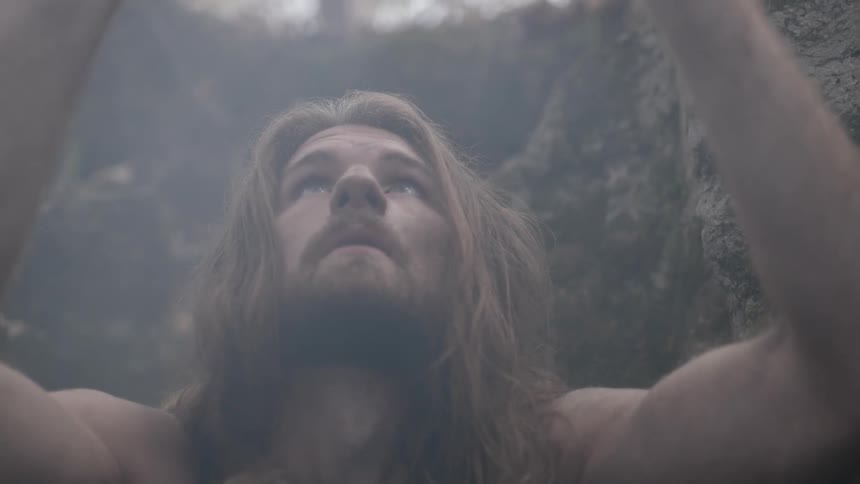 Caveman holding and examining a rock