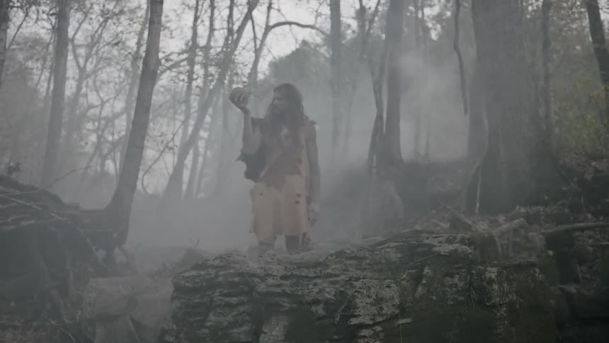 A man stands in a foggy forest