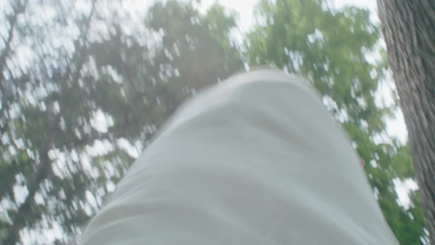 A woman is dancing outdoors in a wooded area