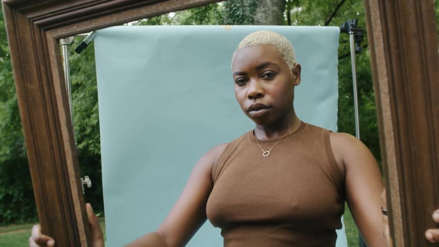 A woman is posing for the camera and is standing outdoors