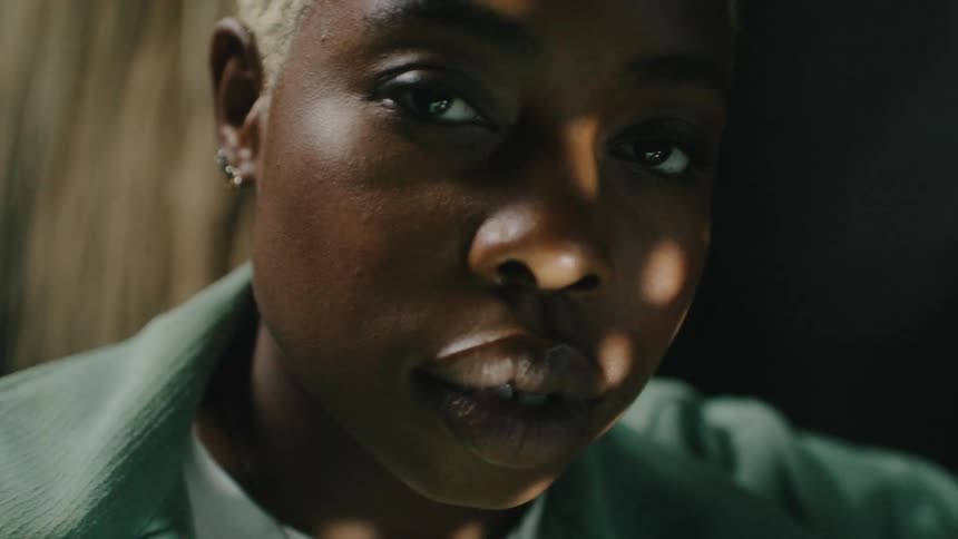 Lights are moving on a womans face as she stares