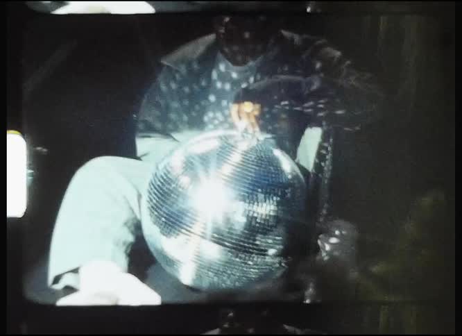 A man is holding a disco ball