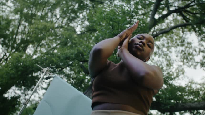 A woman is dancing outdoors during the spring time