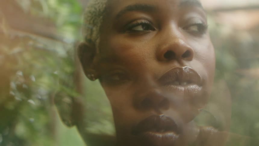A woman turns her head as she poses outside for an artistic photograph
