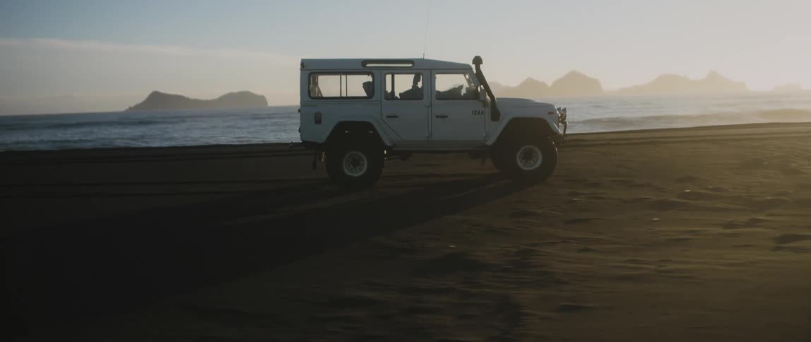 A vehicle is driving on the beach