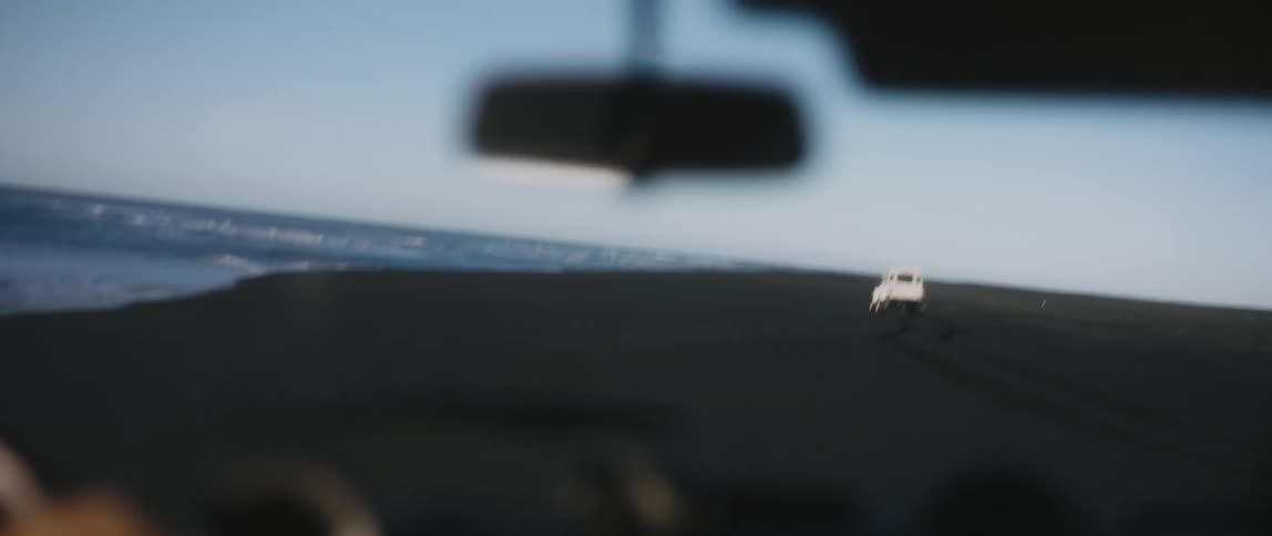 Cars are driving on the coast of a beach