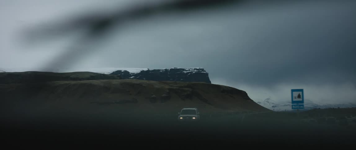 Vehicles drive down a rural highway in dust storm