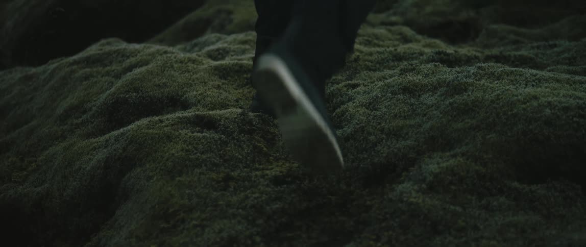 A man walks up the side of a sand dune