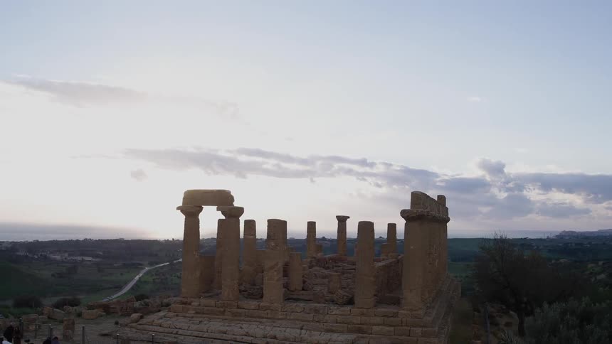Ruins sit in a rural area at sunset