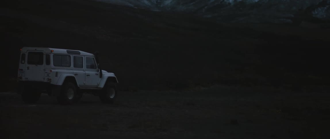 A car is driving through a winter tundra