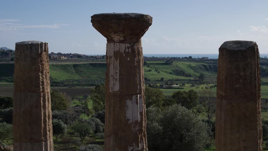 Old pillars stand in a rural area on a sunny day