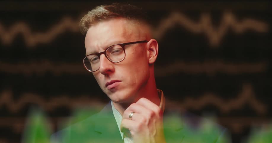 A man is thinking as he stares at data on graphs