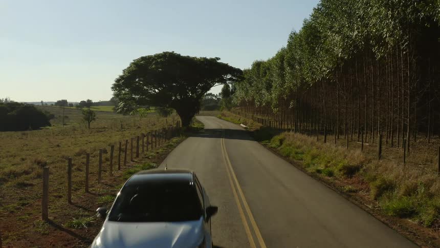 A car drives down a road in a rural area