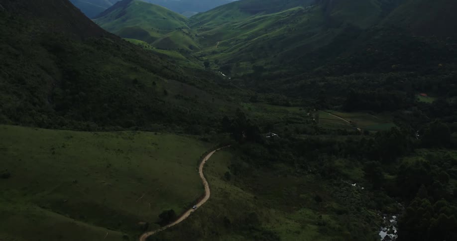 Aerial view of a road on the slopes of a mountain running through a valley on a rural area